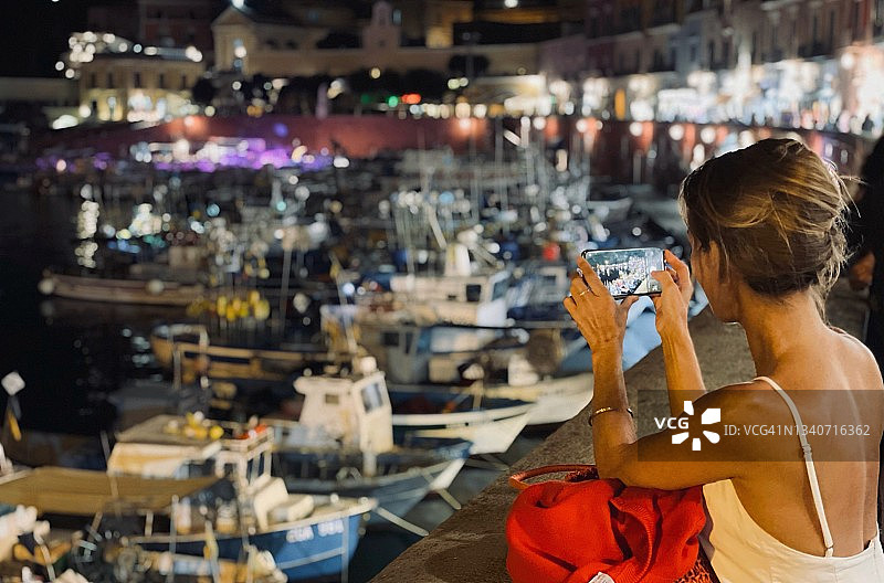 女人在意大利蓬扎港口夜景拍照图片素材