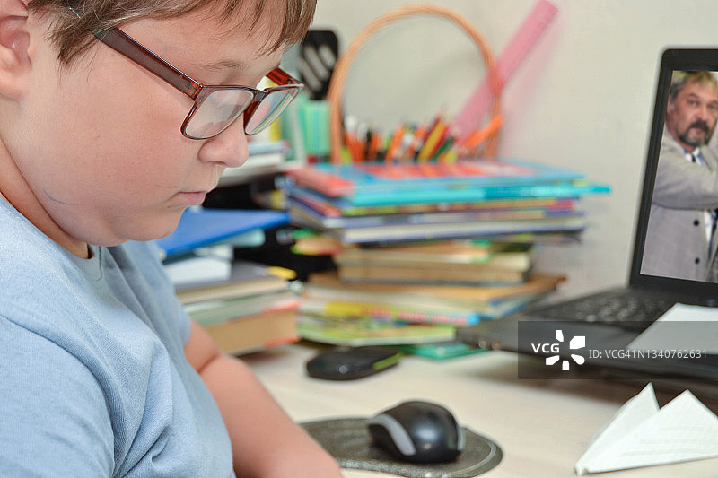 在家通过在线视频课程与老师一起学习的学童图片素材