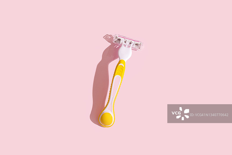 粉色背景上的黄色剃须刀片图片素材