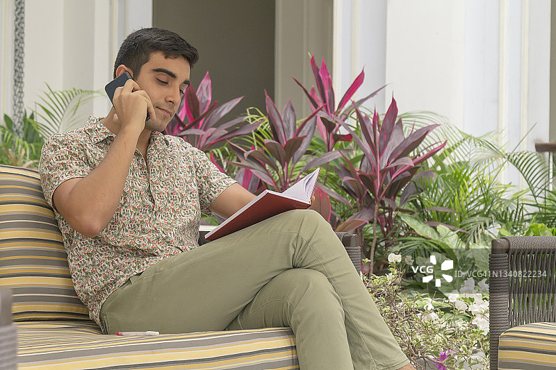 在厄瓜多尔瓜亚基尔老城区使用5G技术旅行并通过智能手机/手机交谈的年轻拉丁裔男子肖像图片素材