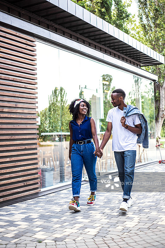 年轻的黑人夫妇在咖啡馆附近户外散步图片素材