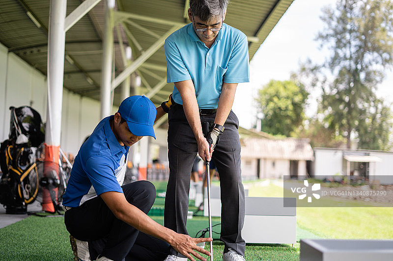 男人教年长的男人打高尔夫图片素材