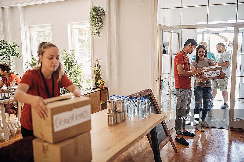 志愿者站在捐赠中心门口，手持捐赠者名单图片素材