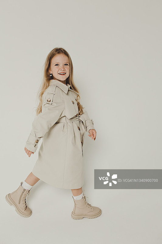 白色背景上身穿秋季风衣的金发美女肖像图片素材