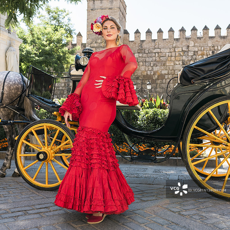 穿着弗拉明戈裙的舞蹈女人站在马车旁图片素材