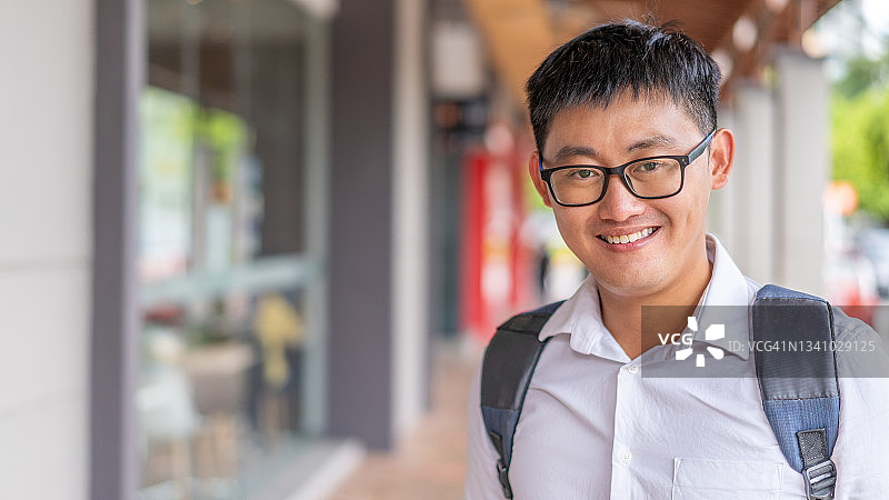 一位面带微笑看向镜头的年轻亚洲男子图片素材