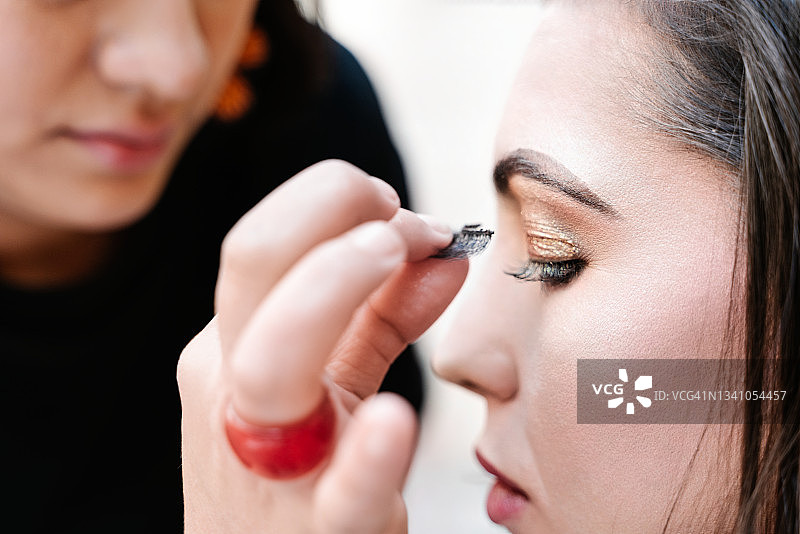 专业化妆师为美丽女人贴假睫毛特写图片素材