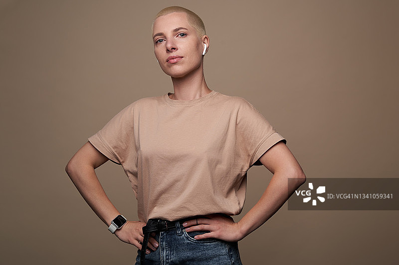 短发年轻女子站在棕色背景前图片素材