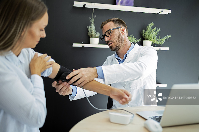 医生准备为年轻女病人量血压图片素材