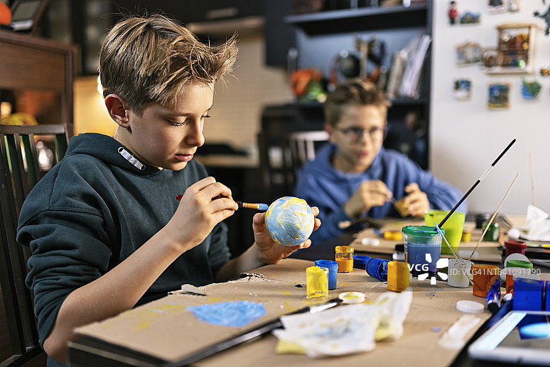 小男孩在家制作太阳系模型图片素材