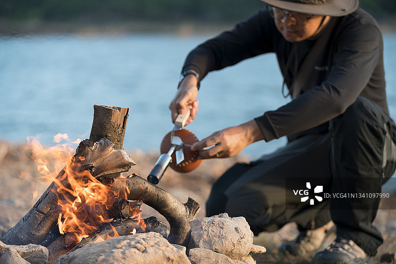 男人在晚上燃烧木柴露营图片素材