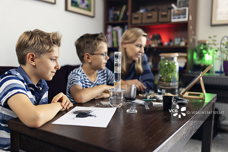 母亲教孩子们关于水净化和过滤的知识图片素材