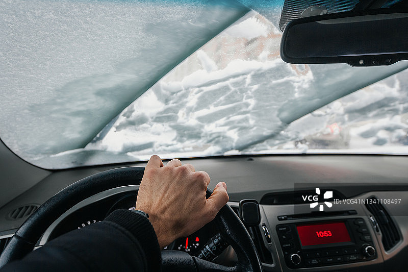 冬季暴风雪中车内视角：挡风玻璃和雨刷正在清除积雪图片素材
