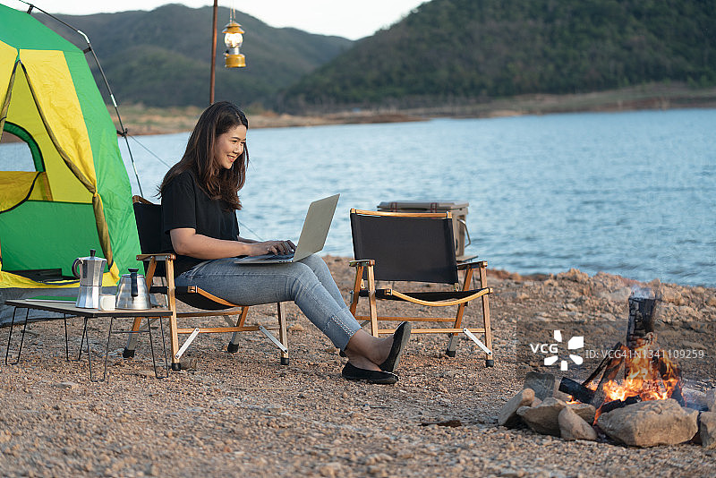 使用笔记本电脑的年轻自由职业者，即使在露营旅行中也在工作图片素材