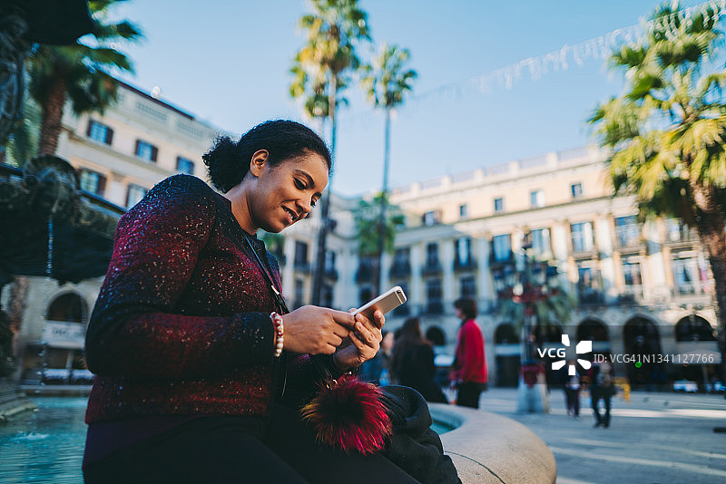 在巴塞罗那使用智能手机的年轻女人图片素材