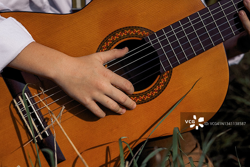 儿童的手在吉他弦上（特写）图片素材