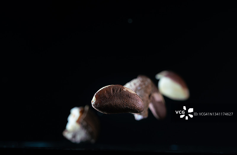 在黑色背景中飞舞的巴西坚果图片素材