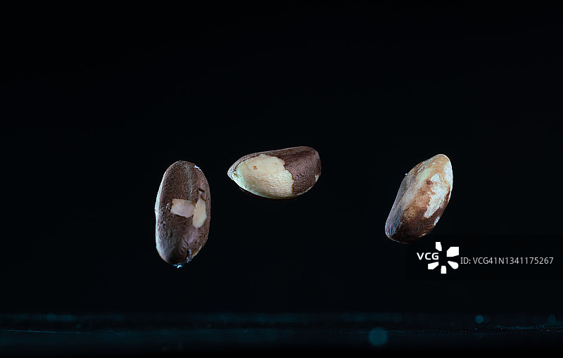 在黑色背景中飞舞的巴西坚果图片素材