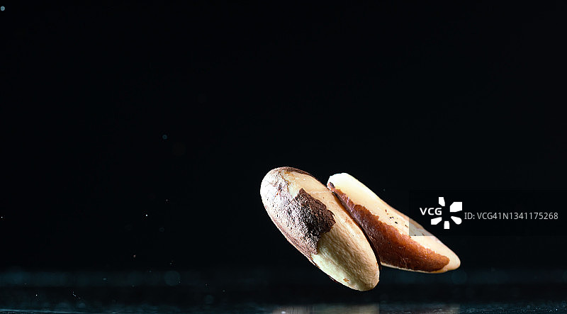 在黑色背景中飞舞的巴西坚果图片素材