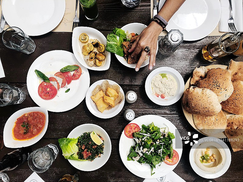 约旦马达巴，一位女士在传统午餐中挑选小吃图片素材