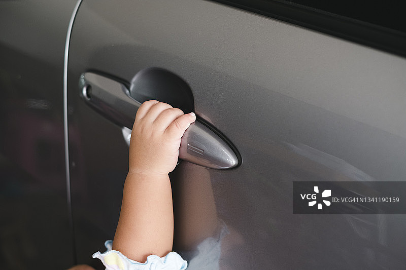 儿童手握灰色车门把手特写图片素材