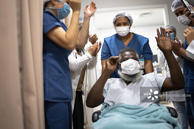 医生和护士庆祝老年男子康复出院——佩戴防护口罩图片素材