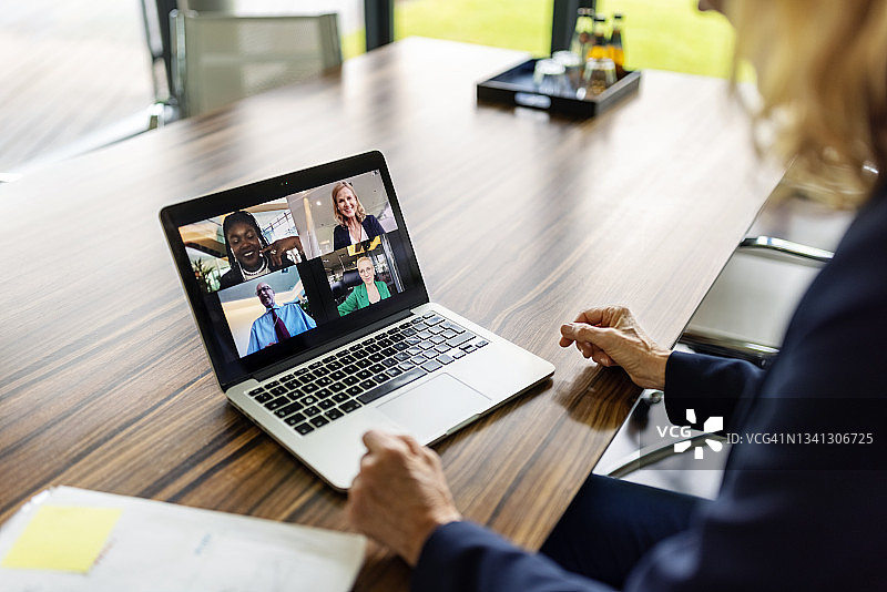 视频通话中笔记本电脑屏幕上的商务人士图片素材