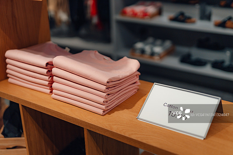 服装店货架上的T恤堆图片素材