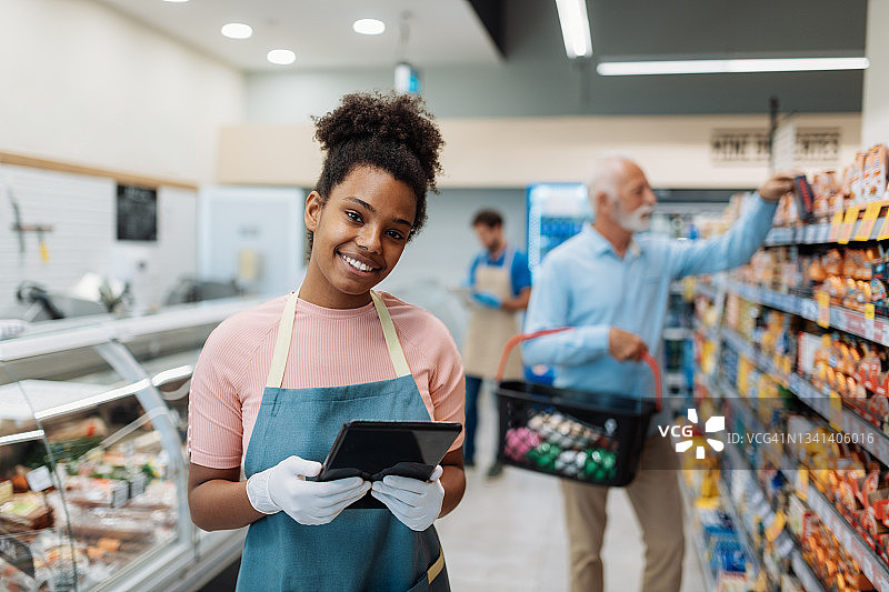 超市员工使用平板电脑并看向镜头图片素材