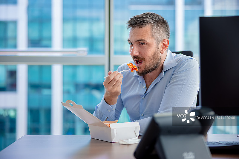 男人在办公室休息时吃外卖图片素材