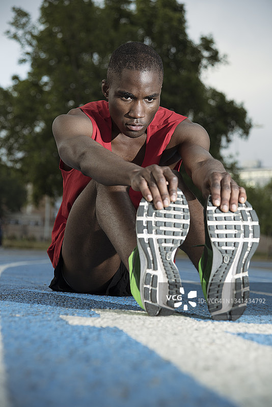 在西班牙加泰罗尼亚巴塞罗那的运动跑道上伸展身体的跑步者图片素材