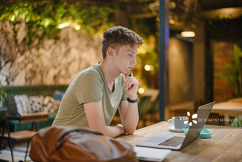 年轻男人在咖啡馆使用笔记本电脑学习图片素材