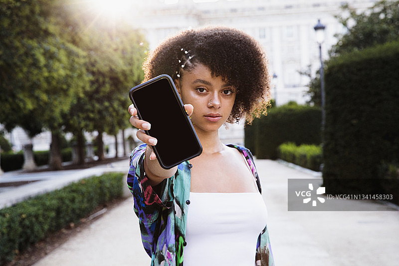 青少年对着镜头展示手机屏幕图片素材