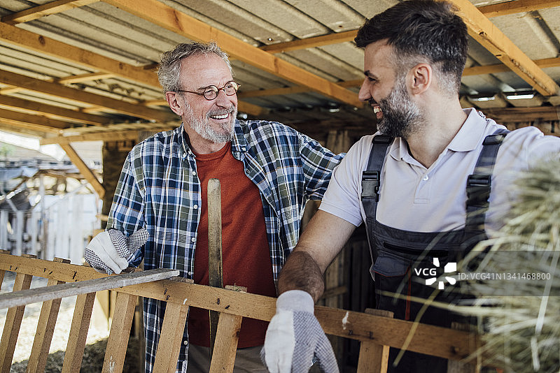 在牧场一起工作的父子肖像图片素材