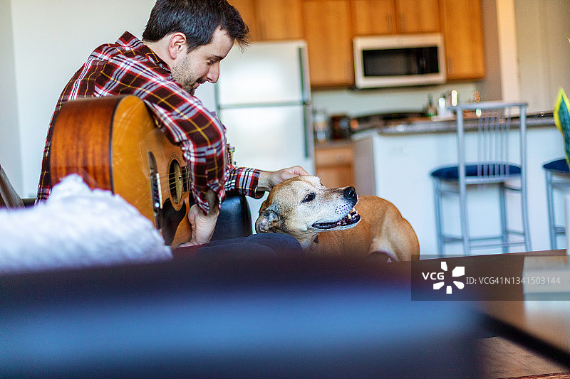 千禧一代男人和宠物狗在室内（中西部照片系列）图片素材