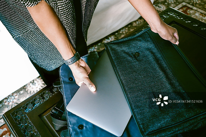 女人从包里取出笔记本电脑图片素材