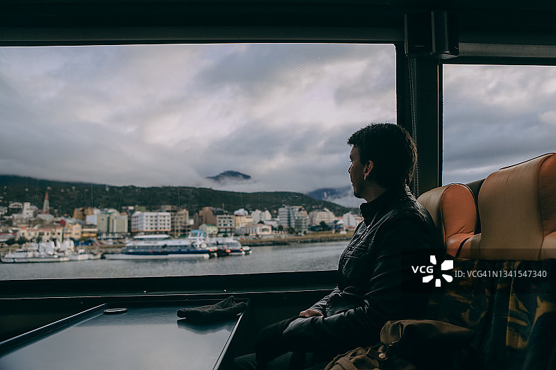 游客在阿根廷乌斯怀亚港口，于船上眺望窗外图片素材