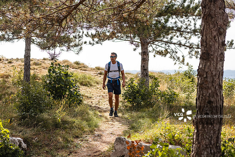 快乐的亚洲中年人在森林中徒步旅行图片素材