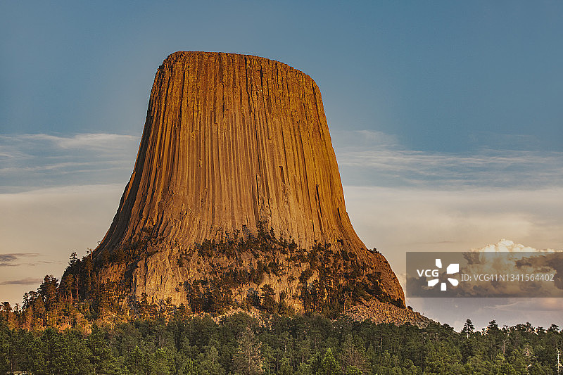 日落时分金色光芒下的魔鬼塔纪念碑岩石图片素材