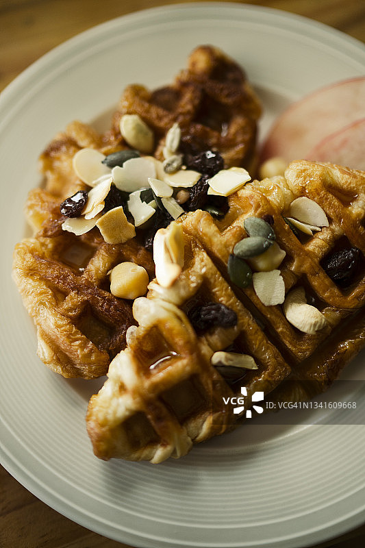 木桌上白色盘子里的可颂华夫饼特写图片素材