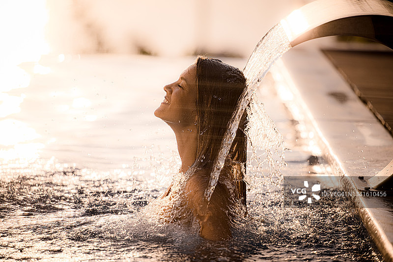 快乐的女人在游泳池里做水疗图片素材
