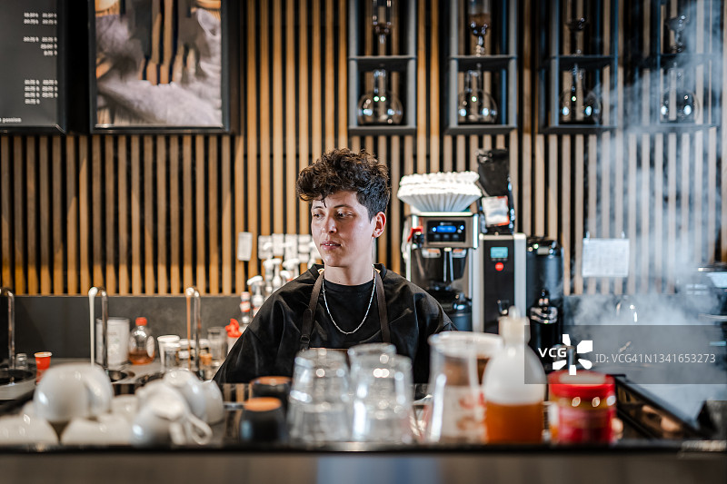 微笑的咖啡师准备在咖啡吧调制饮品图片素材