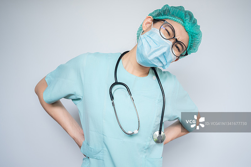 因努力工作而背痛的亚洲医护人员图片素材