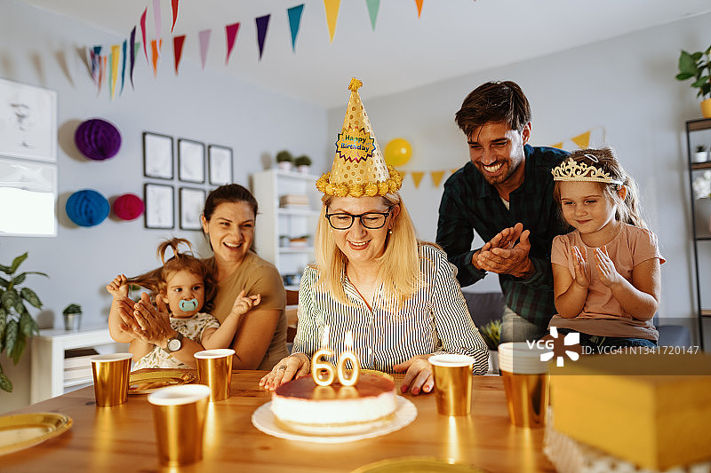 家人在家为奶奶庆祝生日，吹蜡烛图片素材