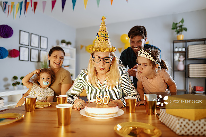 家人在家为奶奶庆祝生日，吹蜡烛图片素材