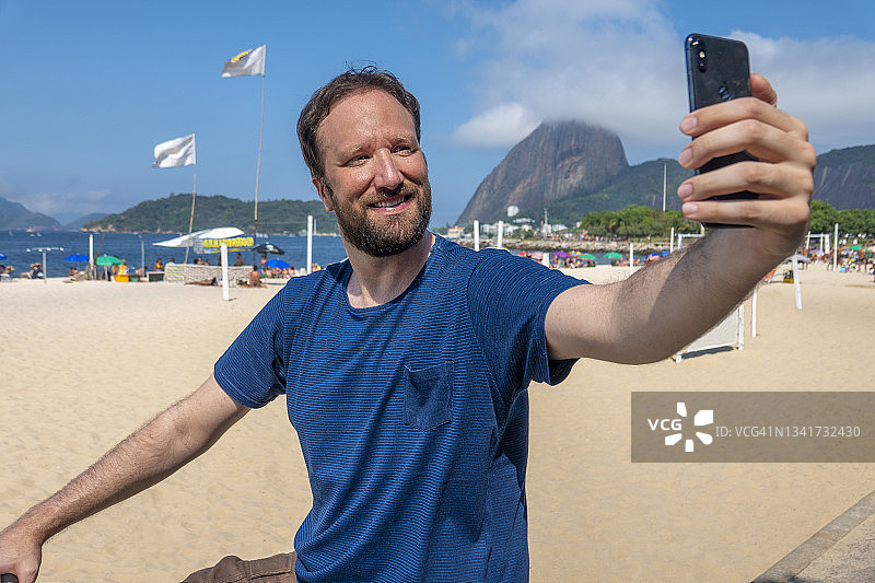 男人在面包山和弗拉门戈海滩背景下自拍图片素材