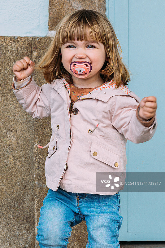 对着镜头微笑的金发小女孩图片素材