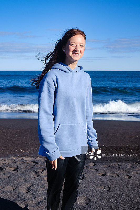 在沙滩上穿着休闲装欢笑的少女图片素材