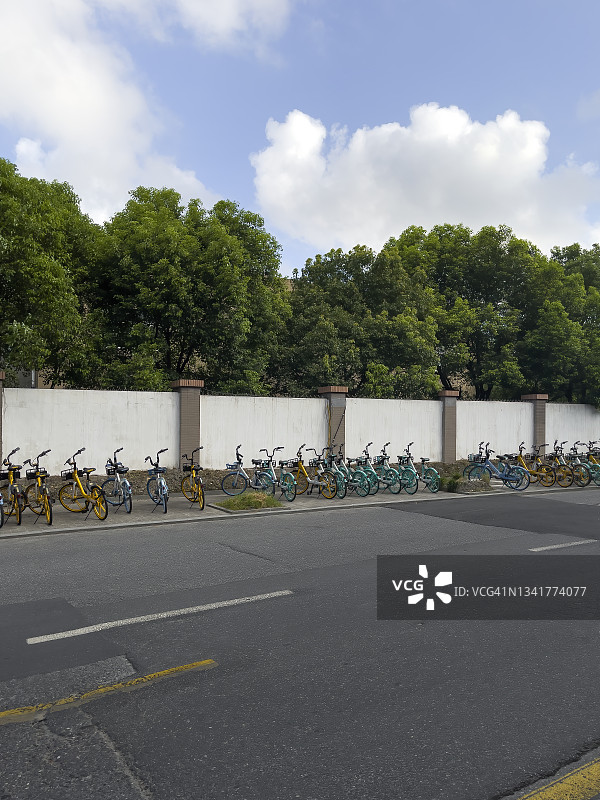 中国杭州路边停放着多种颜色的共享单车图片素材