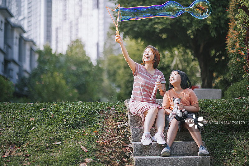 中国母女在后院和猫玩泡泡图片素材